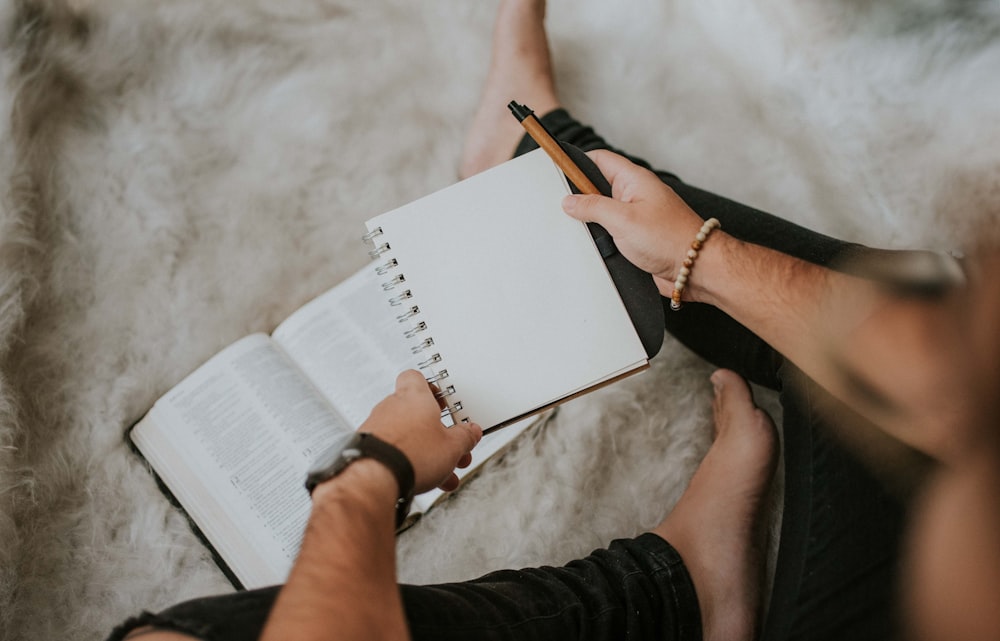 person holding pen and notebook