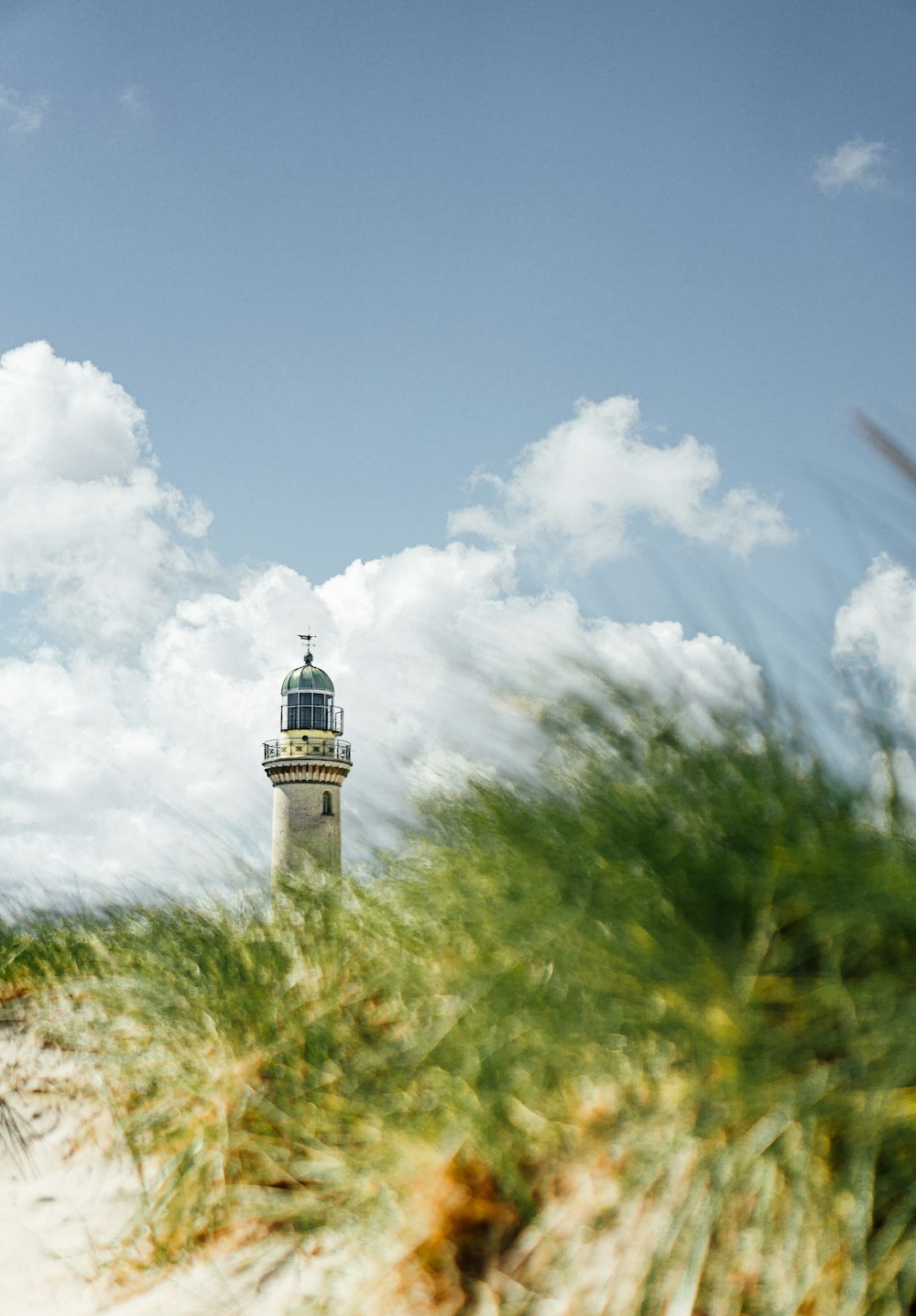 weißer und schwarzer Leuchtturm unter weißen Wolken und blauem Himmel tagsüber