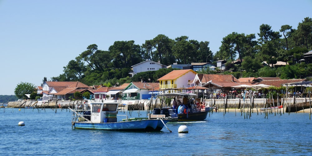 blue and white boat on water near houses during daytime