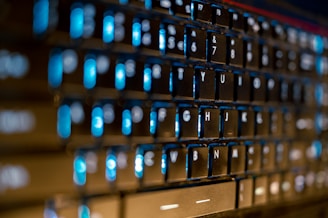 Close-up of hands typing on a futuristic keyboard with glowing keys in a corporate environment.
