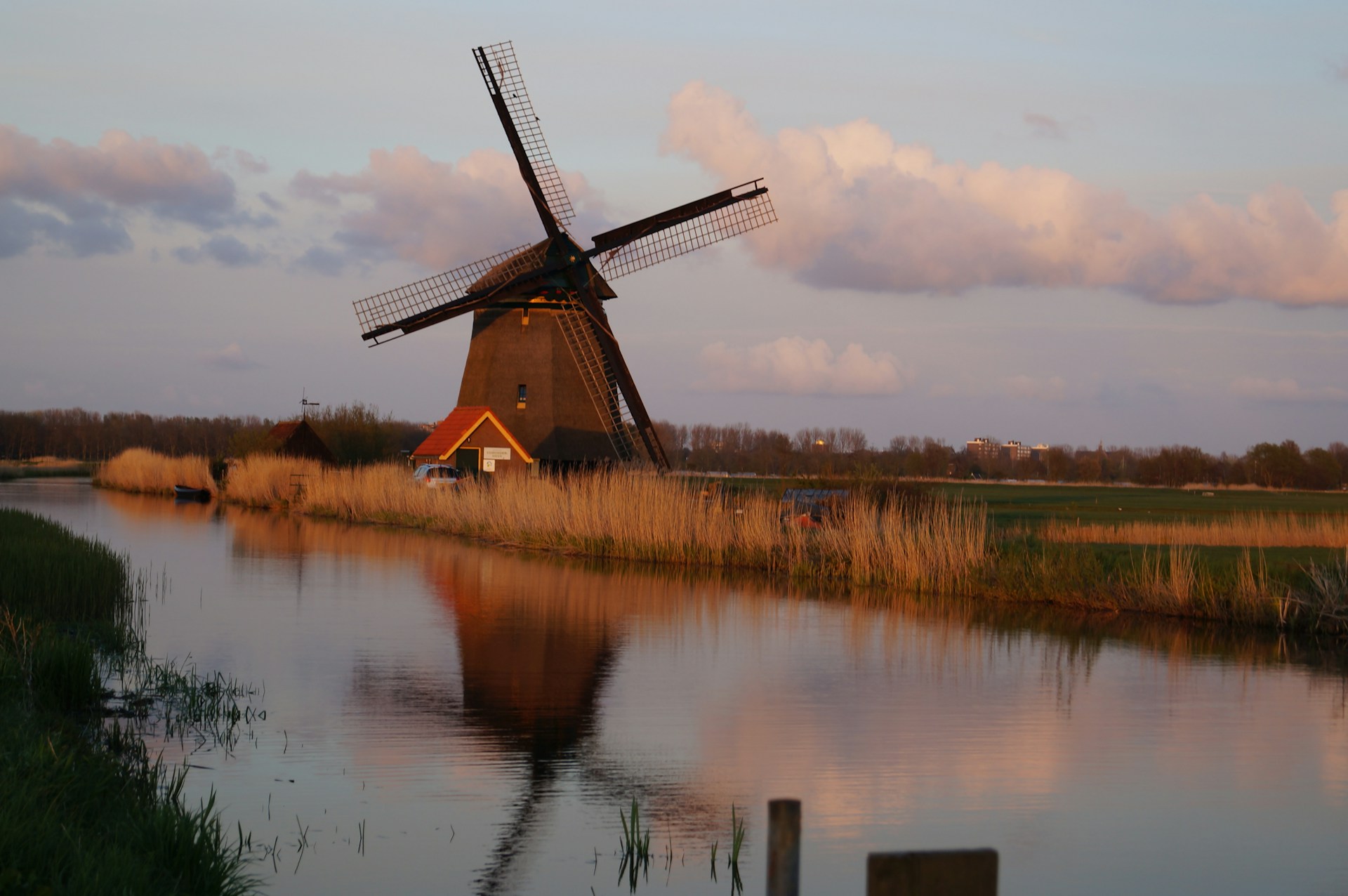 brown windmill near body of water during daytime