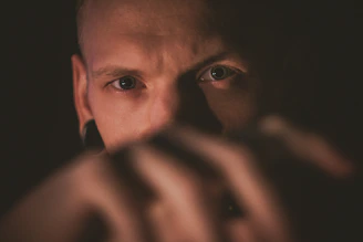 Close-up of a fighter’s eyes showing intense mental focus in low light.