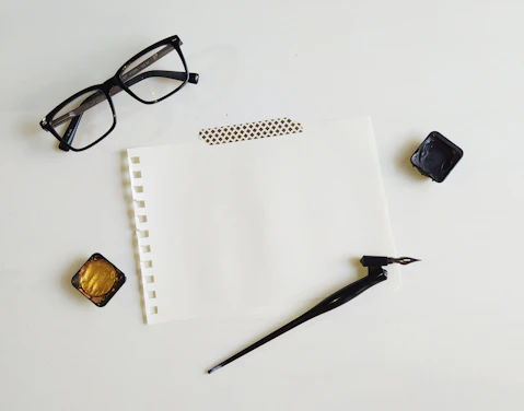black framed eyeglasses on white printer paper