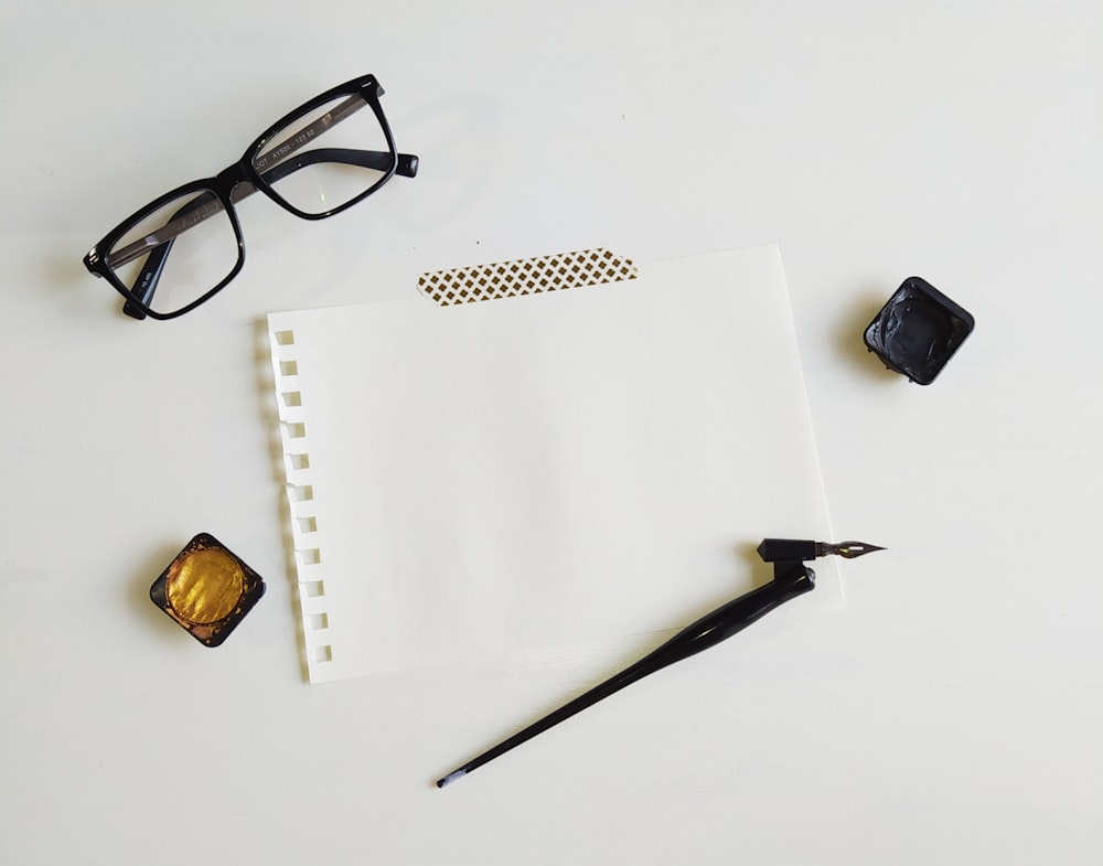 black framed eyeglasses on white printer paper