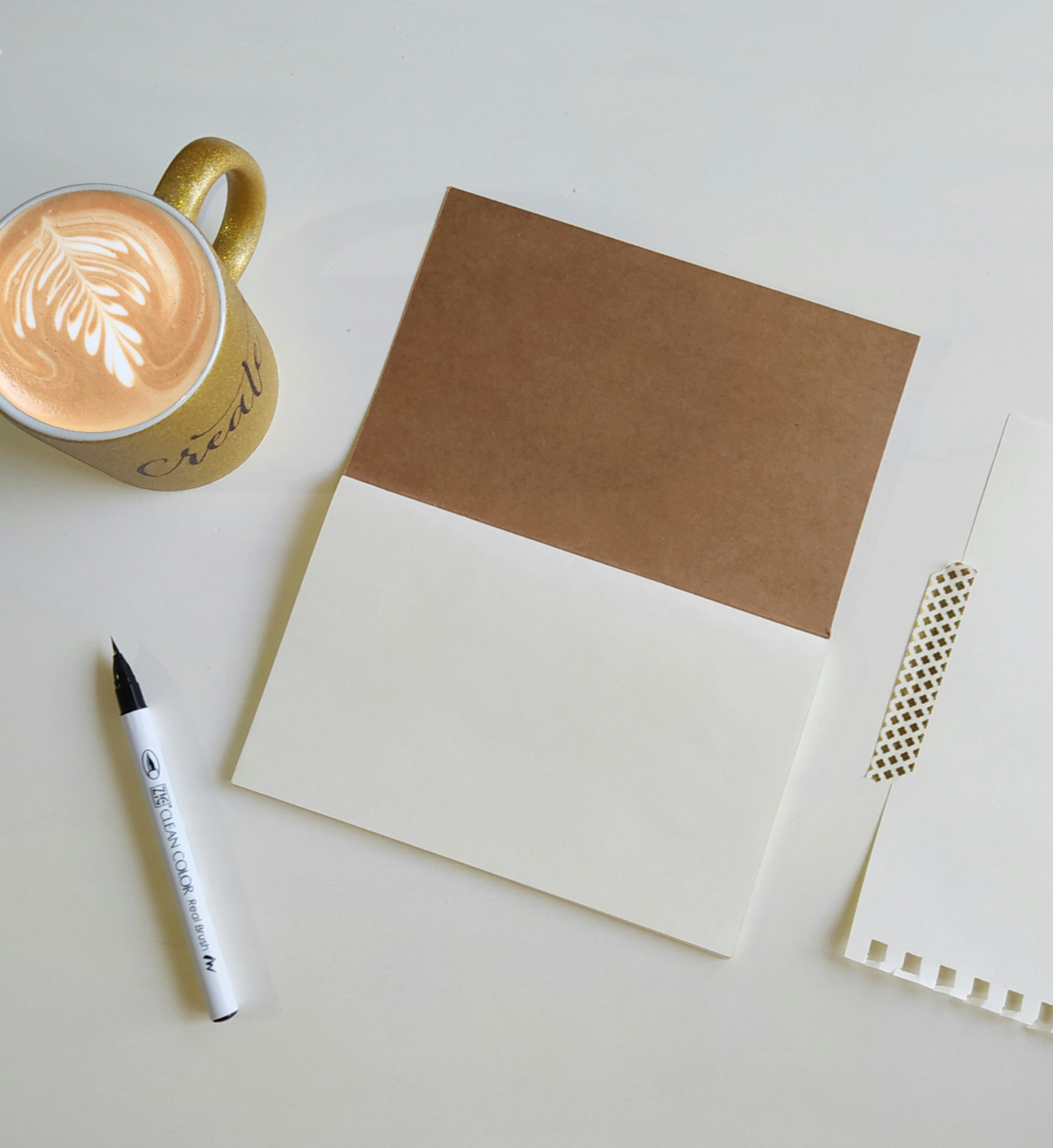 An open notebook, pen and a cup of coffee
