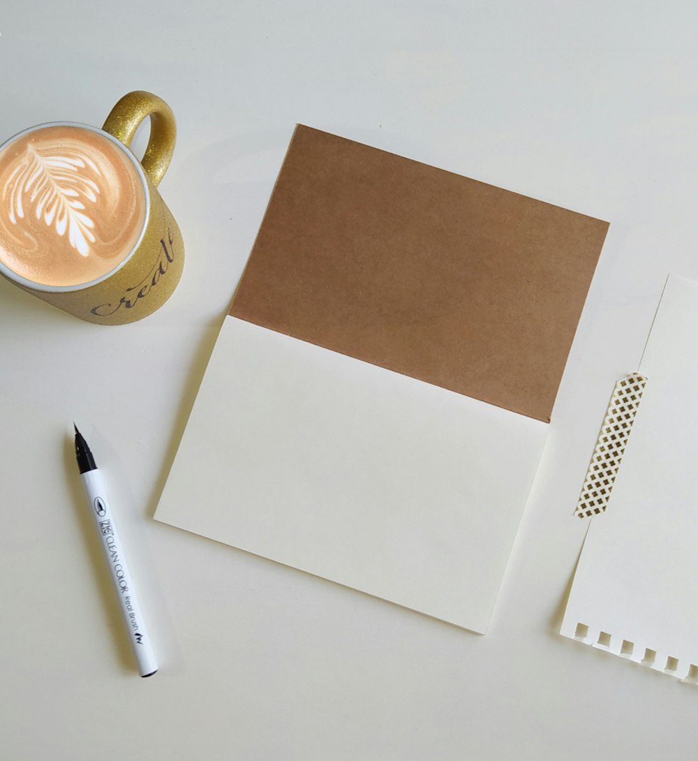 papel de impressora branco ao lado de caneta preta e papel branco