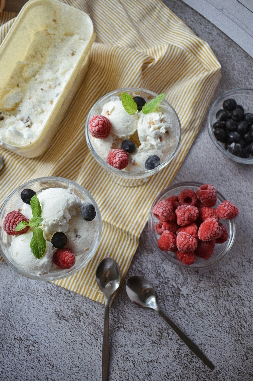 white ice cream with strawberries and blueberries on brown wooden tray