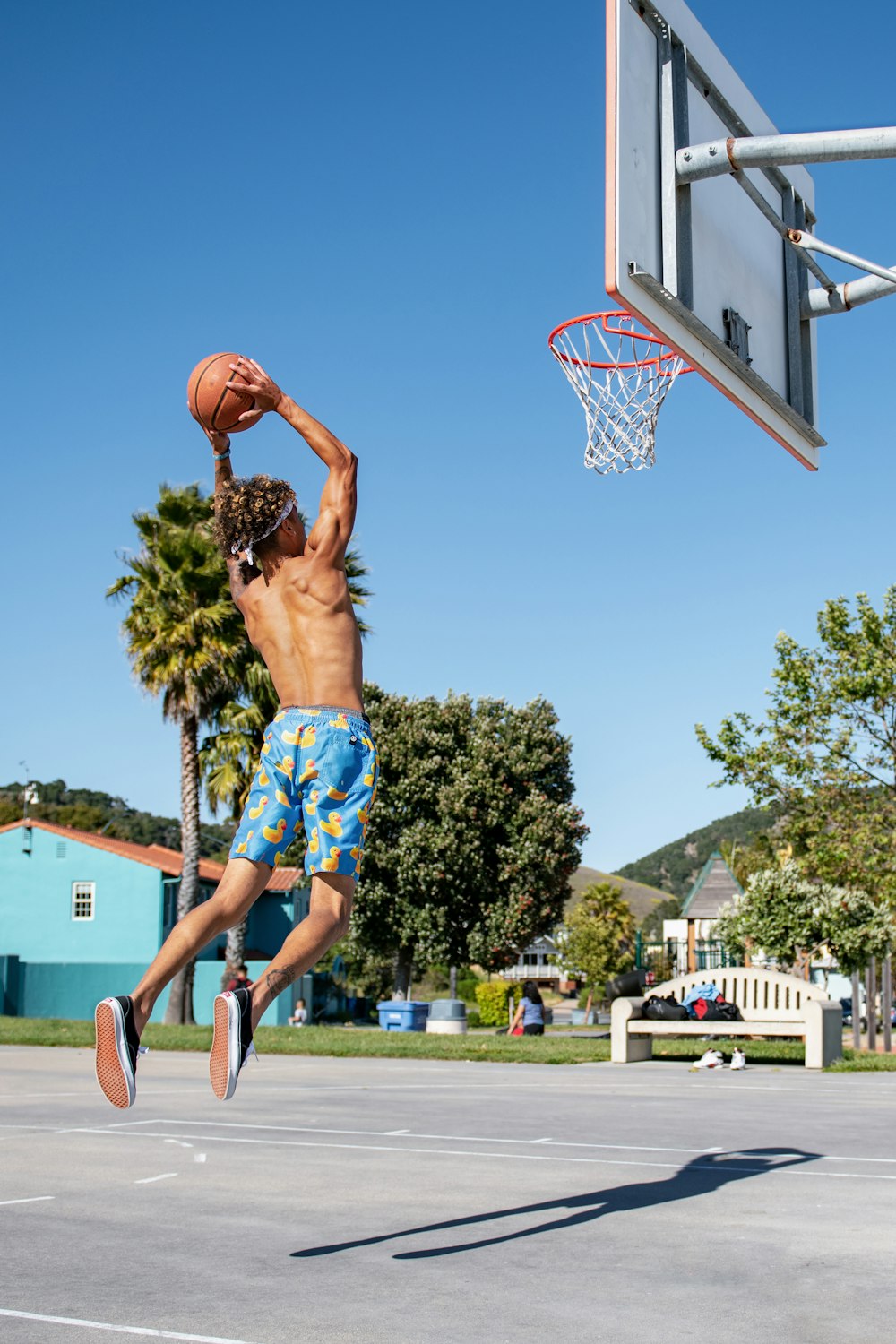 mulher em calções azuis e brancos que jogam basquete durante o dia