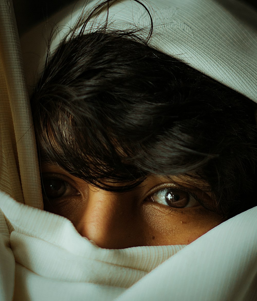 woman covering her face with white textile