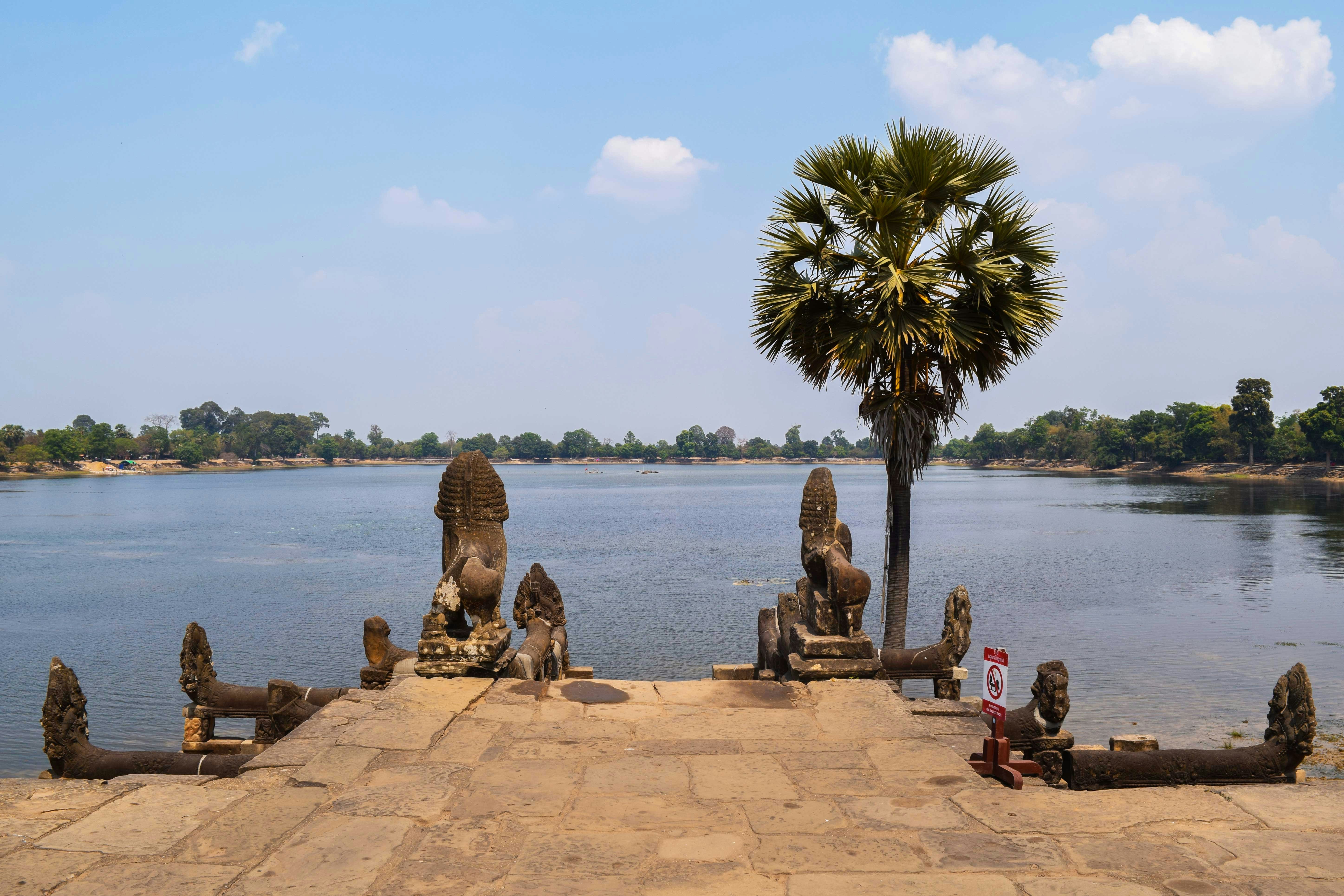 people sitting on brown concrete bench near body of water during daytime