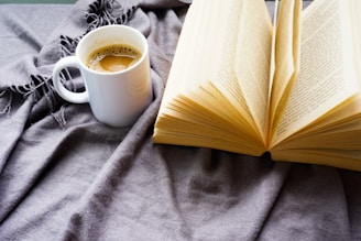 A cozy coffee setup with a steaming cup, vintage brewing tools, and an open book on stoic philosophy.
