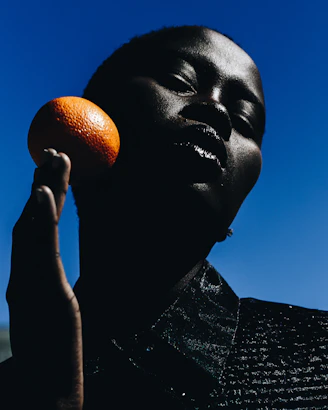 woman holding orange fruit during daytime