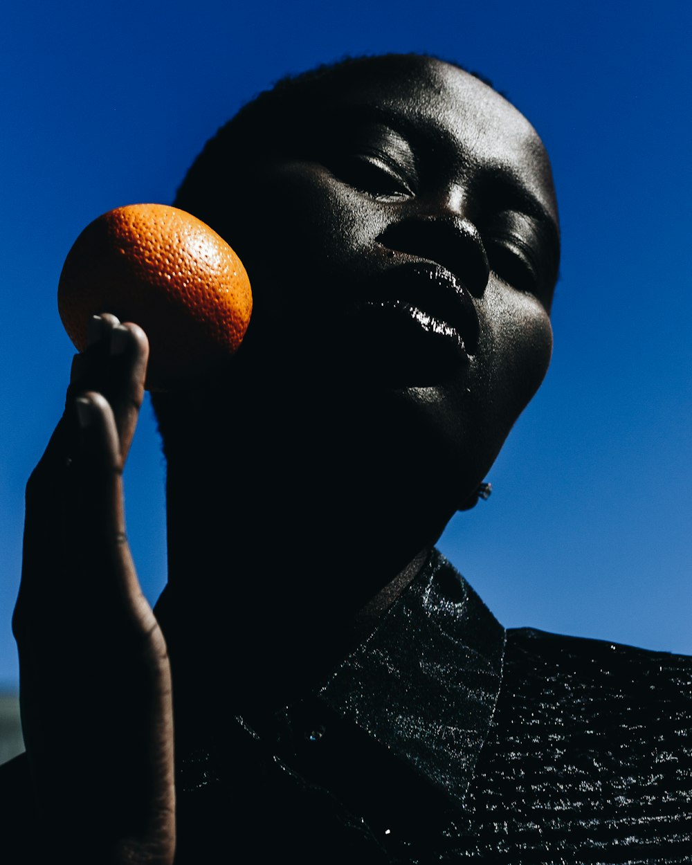 Mujer sosteniendo fruta naranja durante el día