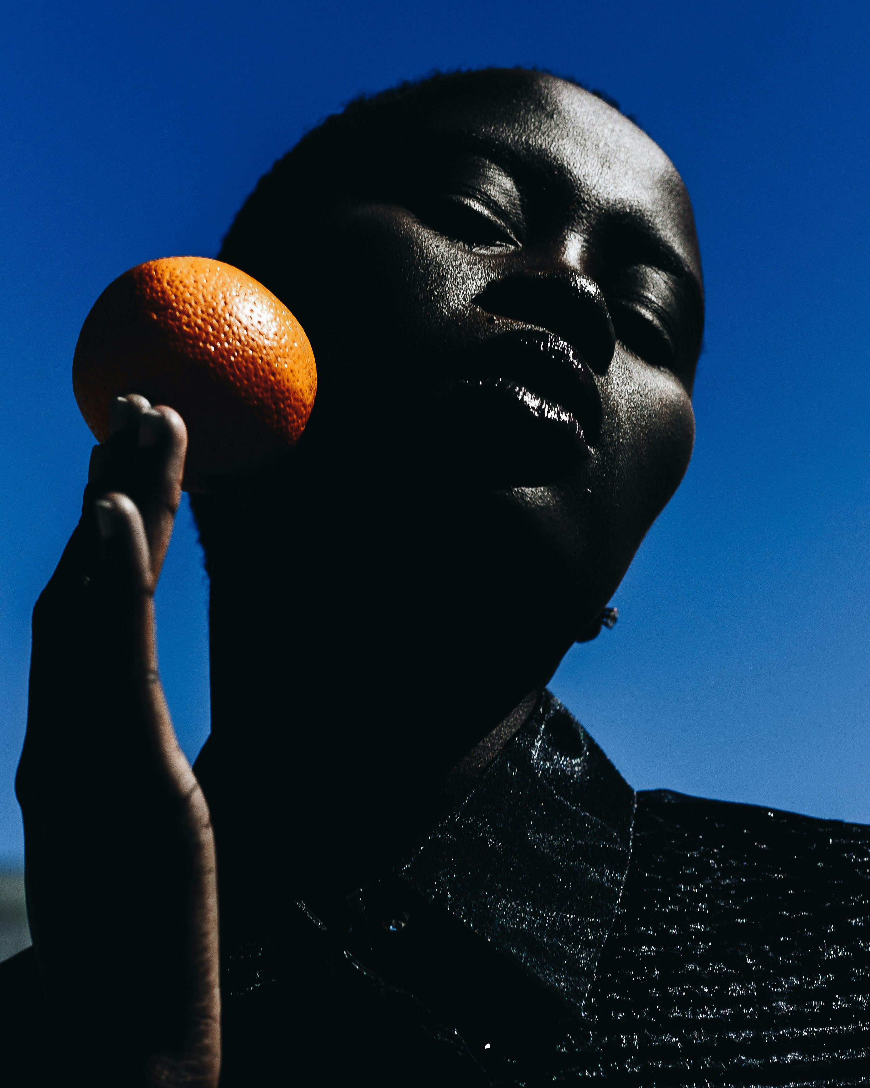 man holding orange fruit during daytime