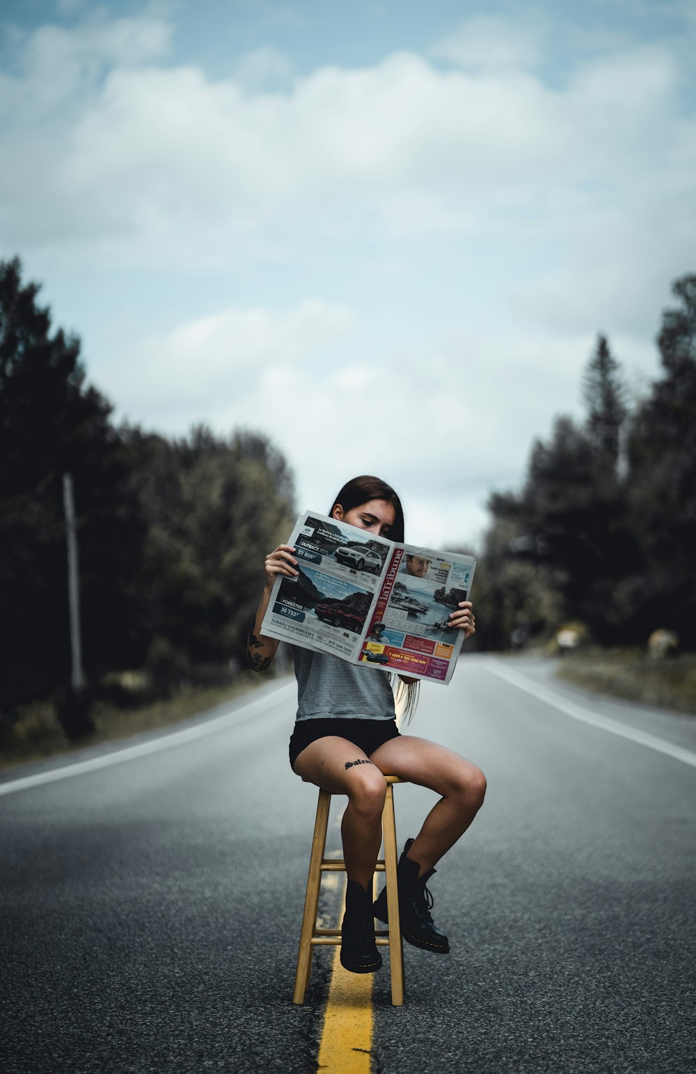 woman in black dress holding magazine