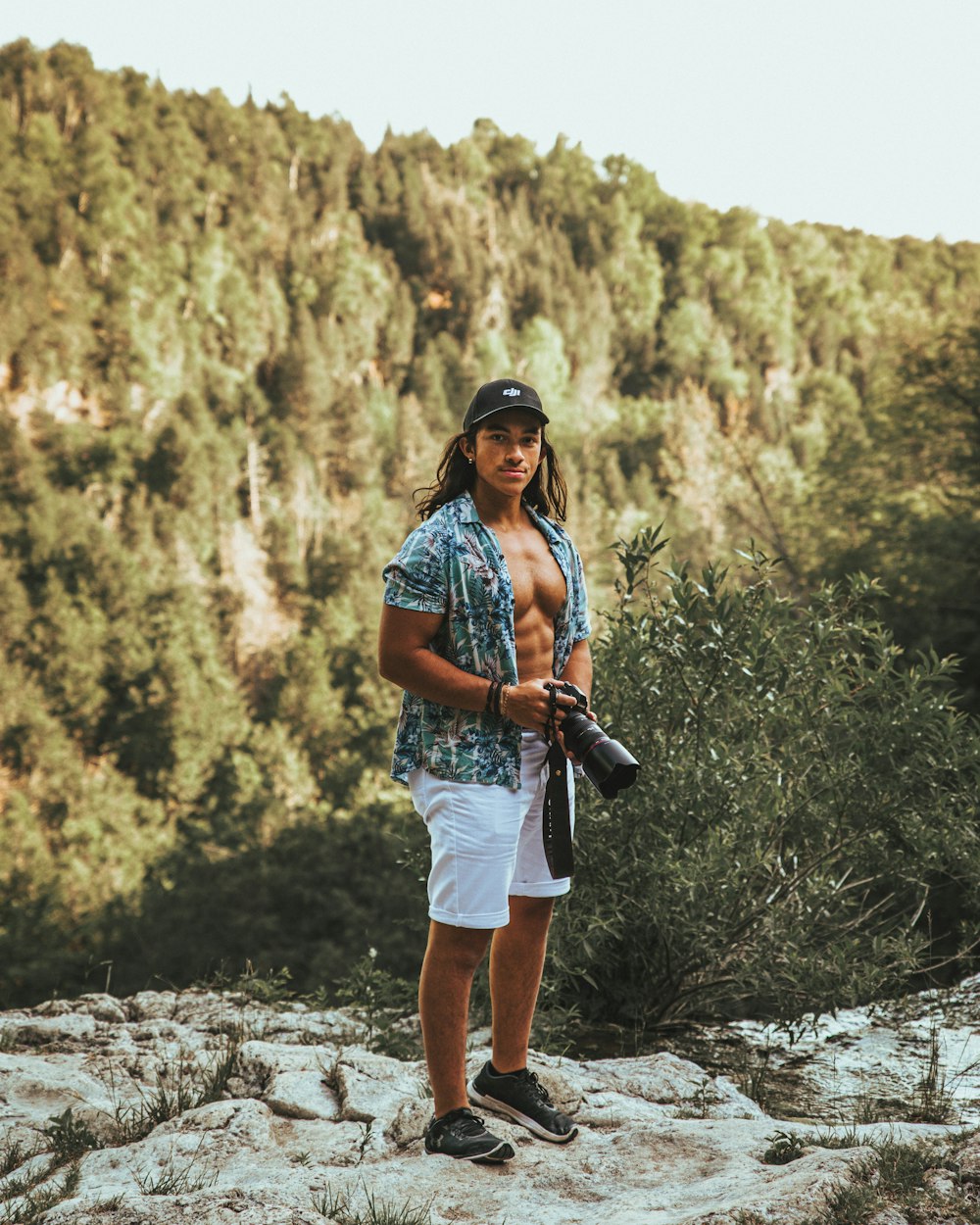 woman in blue denim vest and white shorts standing on rocky ground during daytime