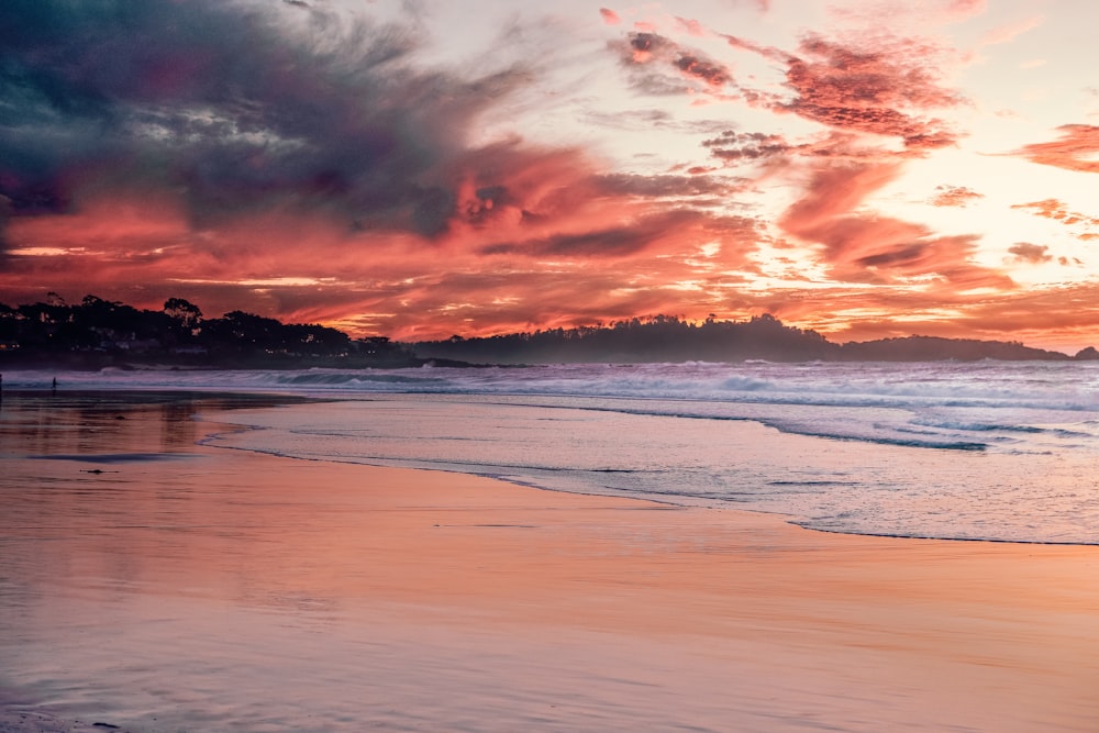 sea waves crashing on shore during sunset