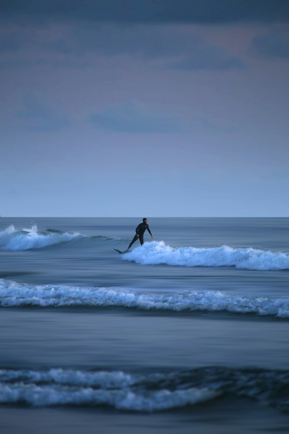 person surfing on sea waves during daytime