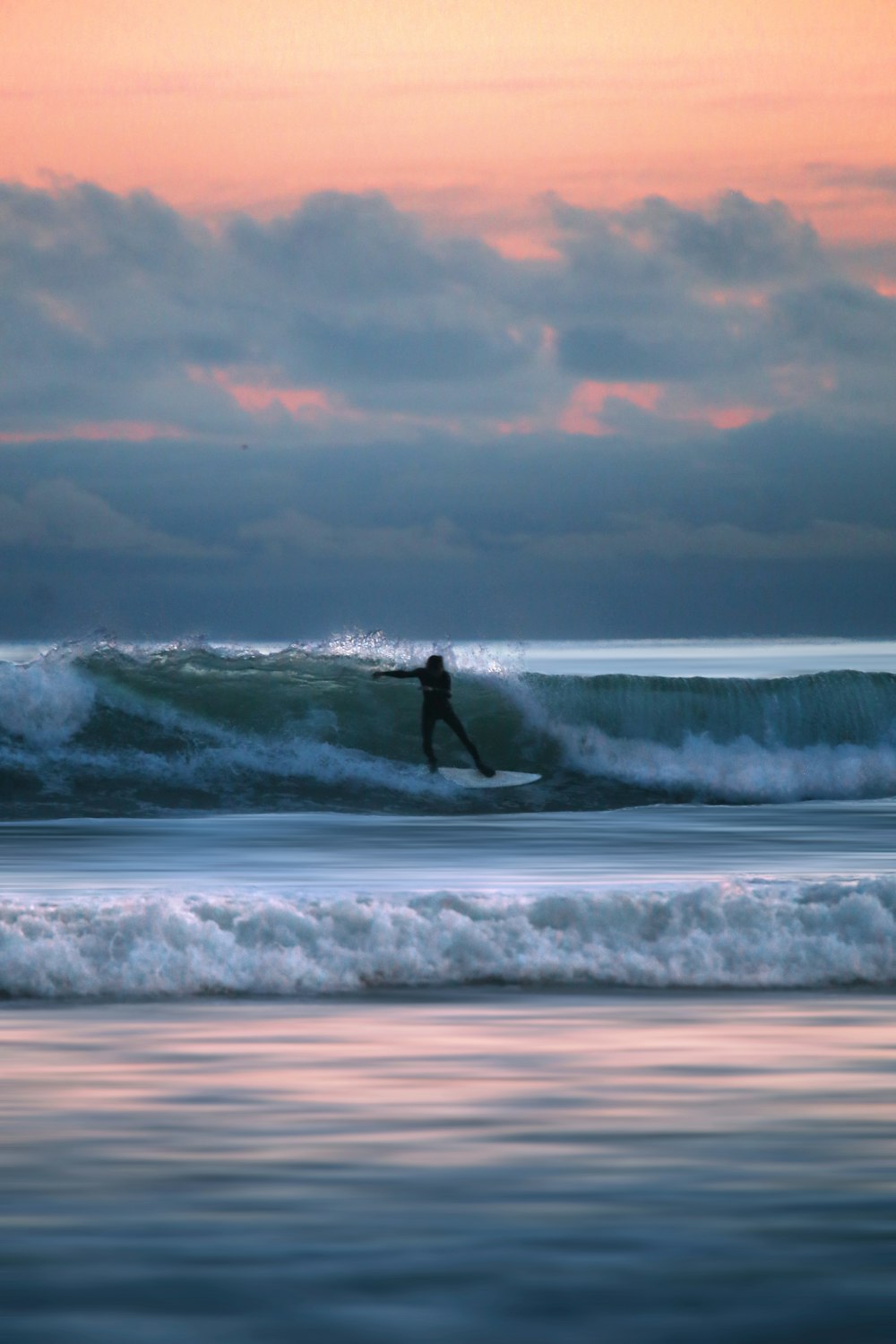 person surfing on sea waves during daytime