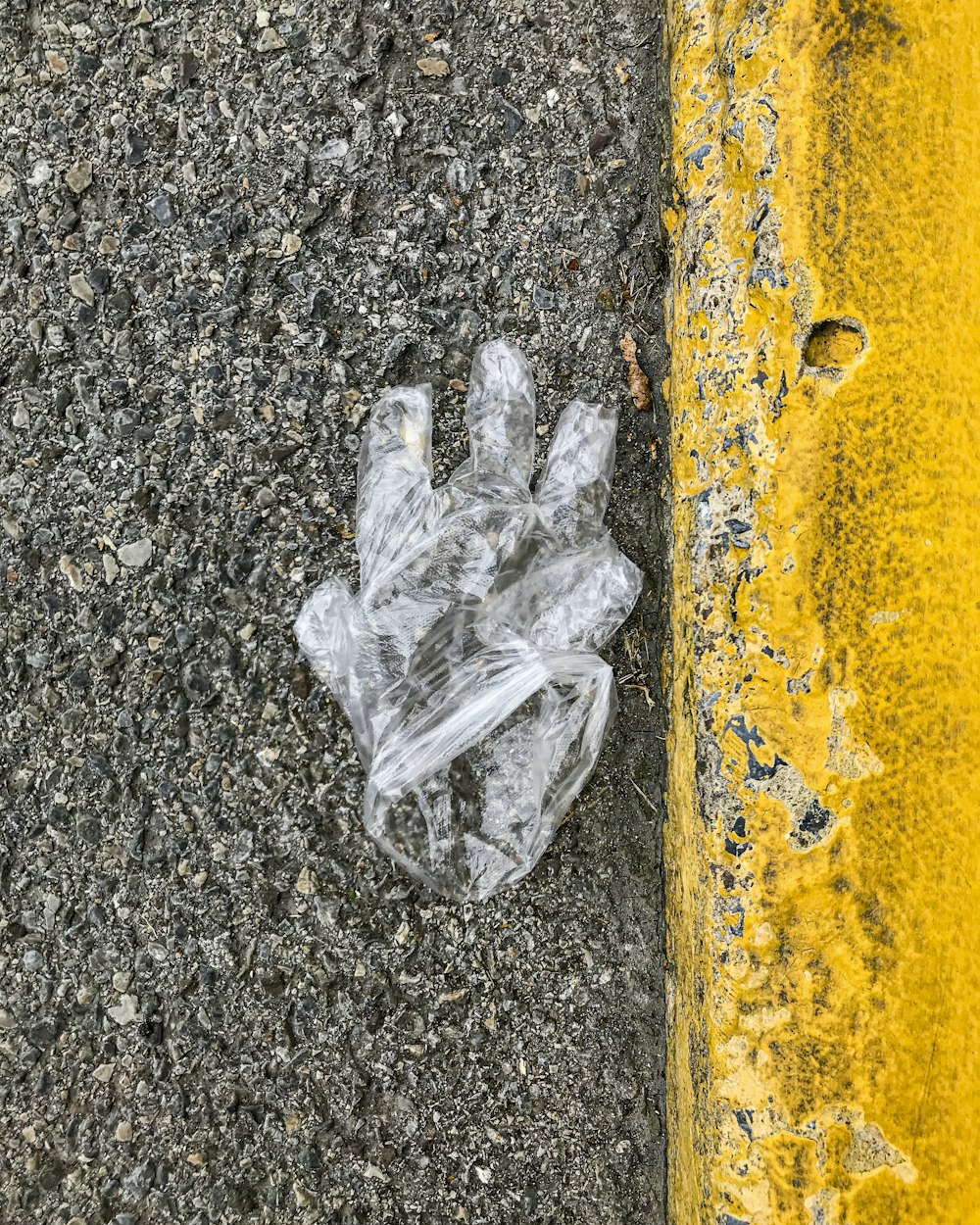 white plastic bag on yellow concrete wall