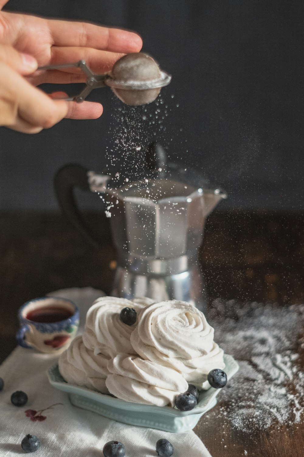 person pouring white cream on silver coffee maker