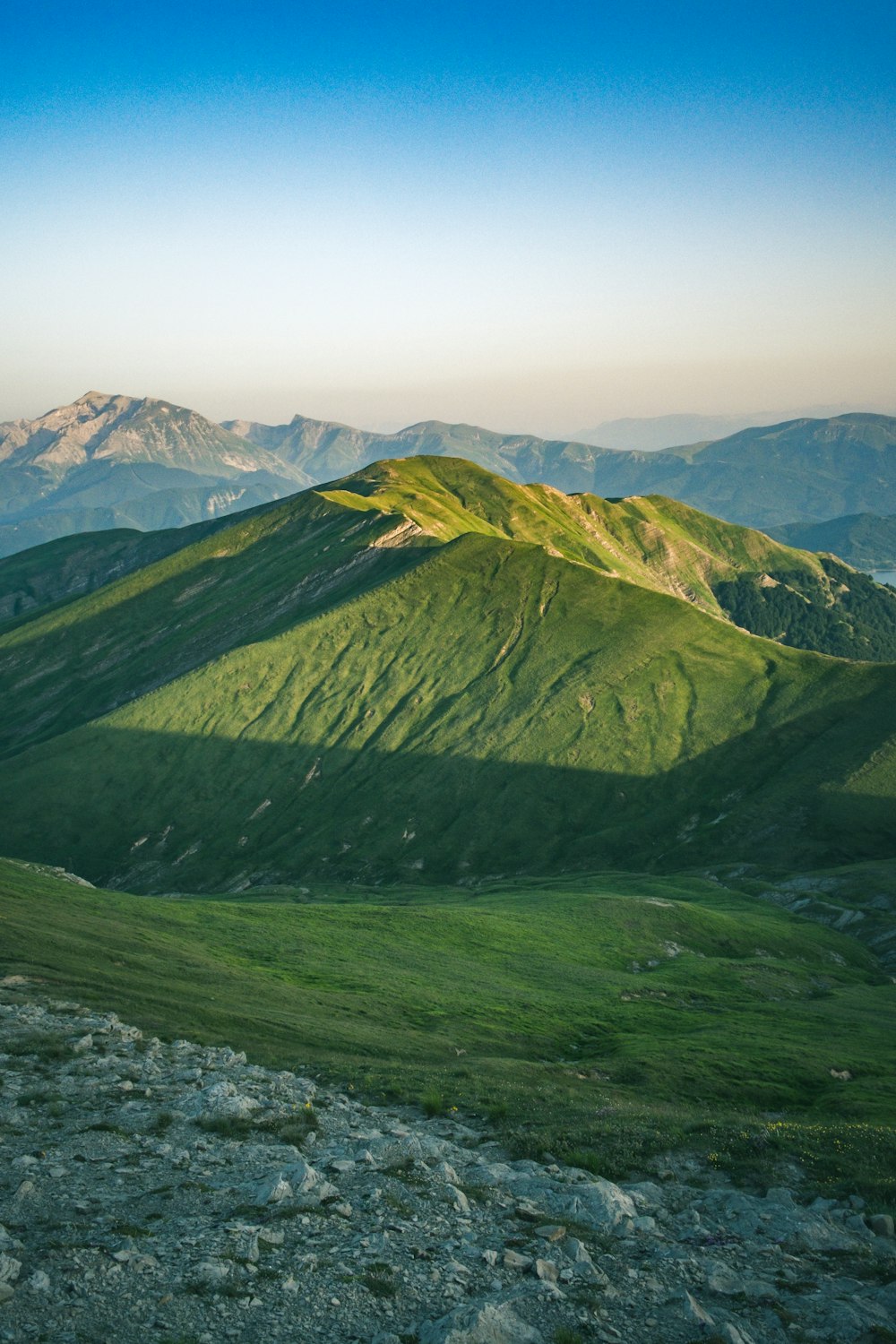 montagnes vertes et noires sous un ciel blanc pendant la journée