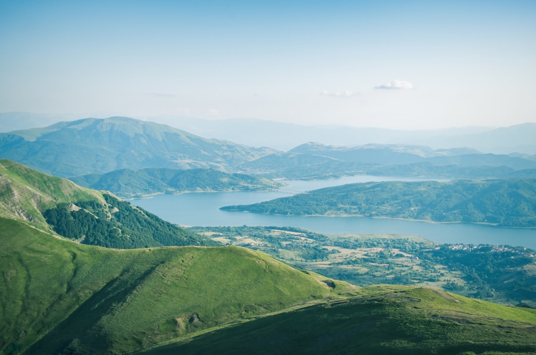 green mountains near body of water during daytime