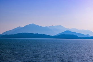 body of water near mountain during daytime