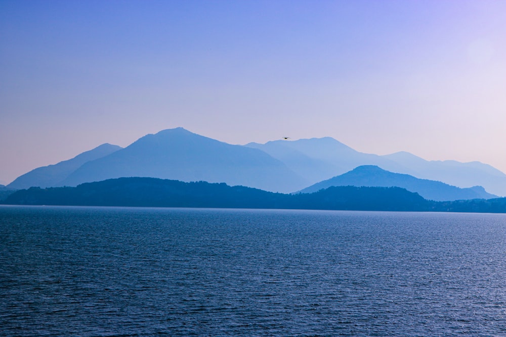 body of water near mountain during daytime