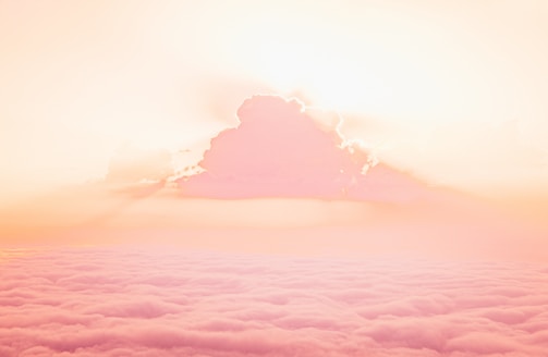 A serene sky with soft clouds and a radiant light symbolizing divine presence