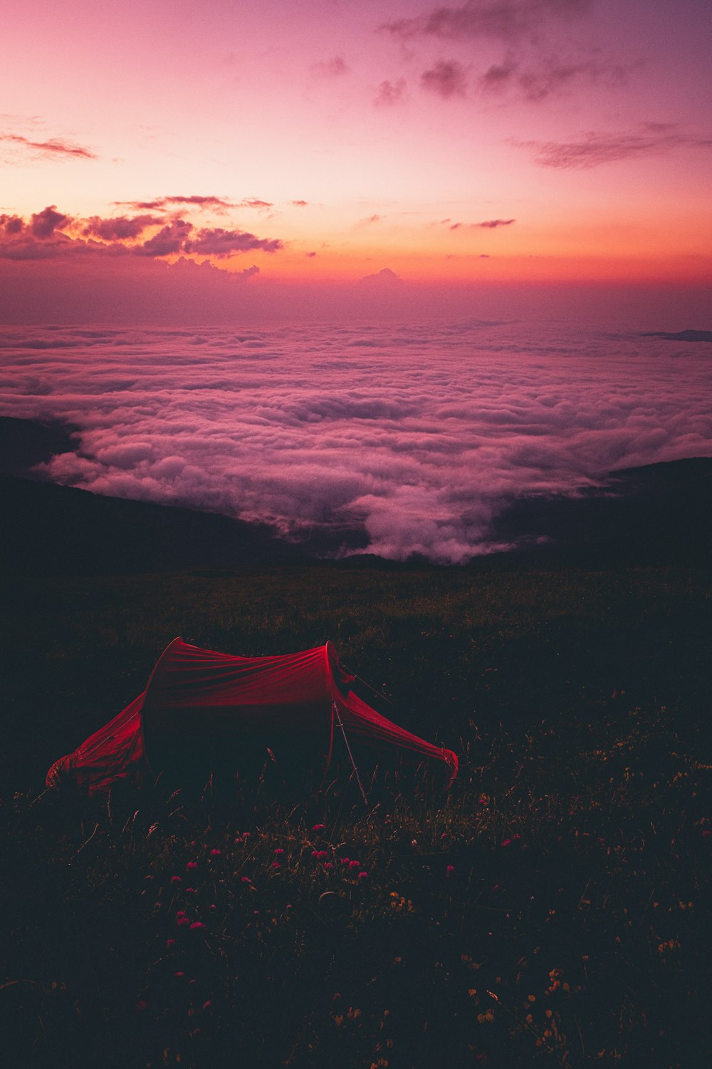 red tent on black and white clouds during sunset