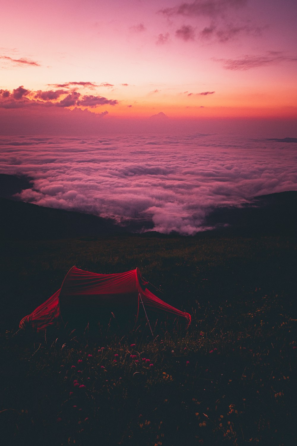 Rotes Zelt auf schwarzen und weißen Wolken bei Sonnenuntergang