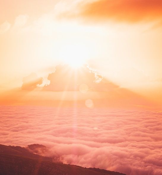 sun rays over clouds and mountains