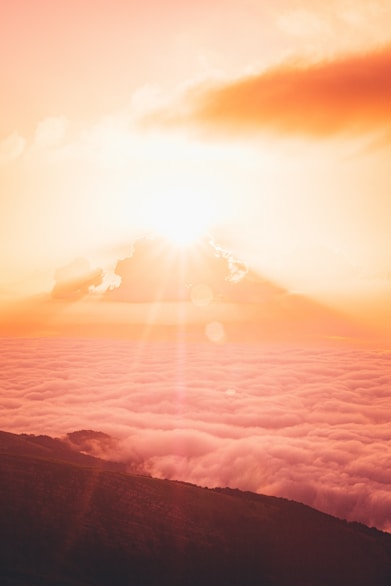 sun rays over clouds and mountains