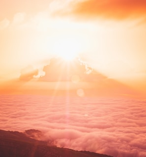 sun rays over clouds and mountains