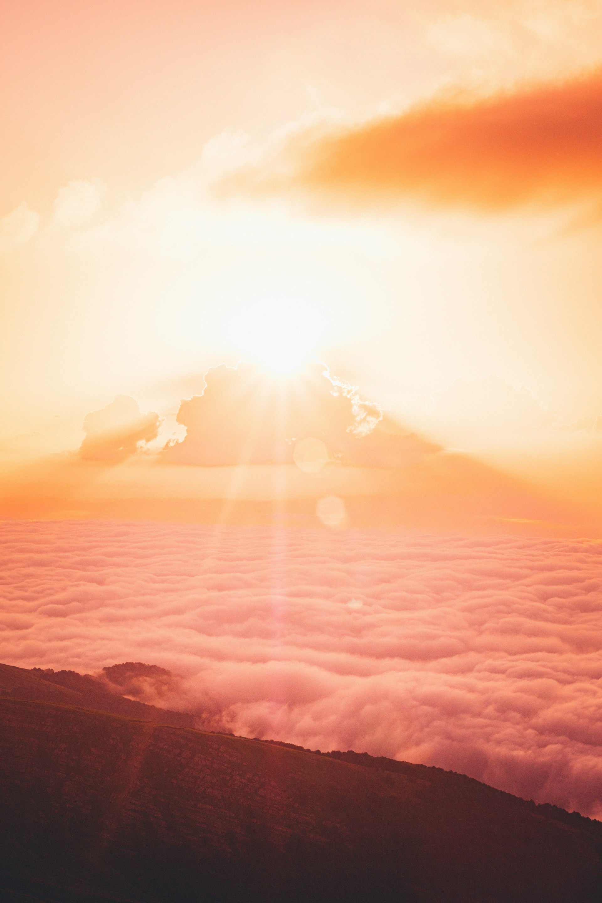 sun rays over clouds and mountains