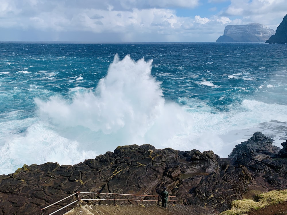 ocean waves crashing on rocky shore during daytime