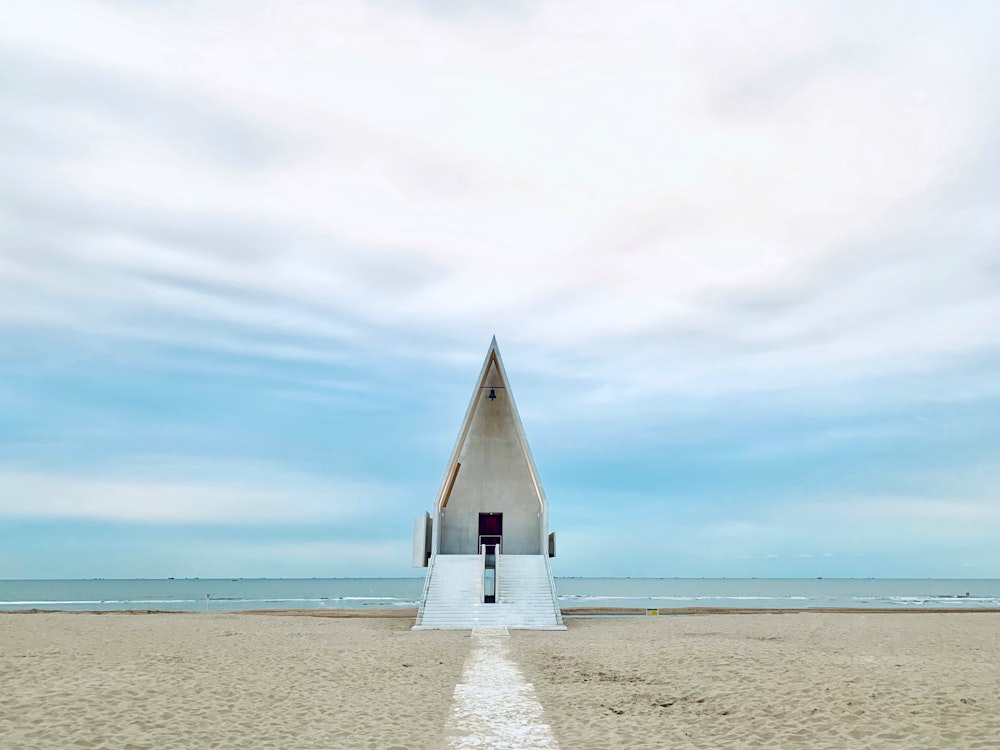 white and brown wooden house on white sand beach during daytime