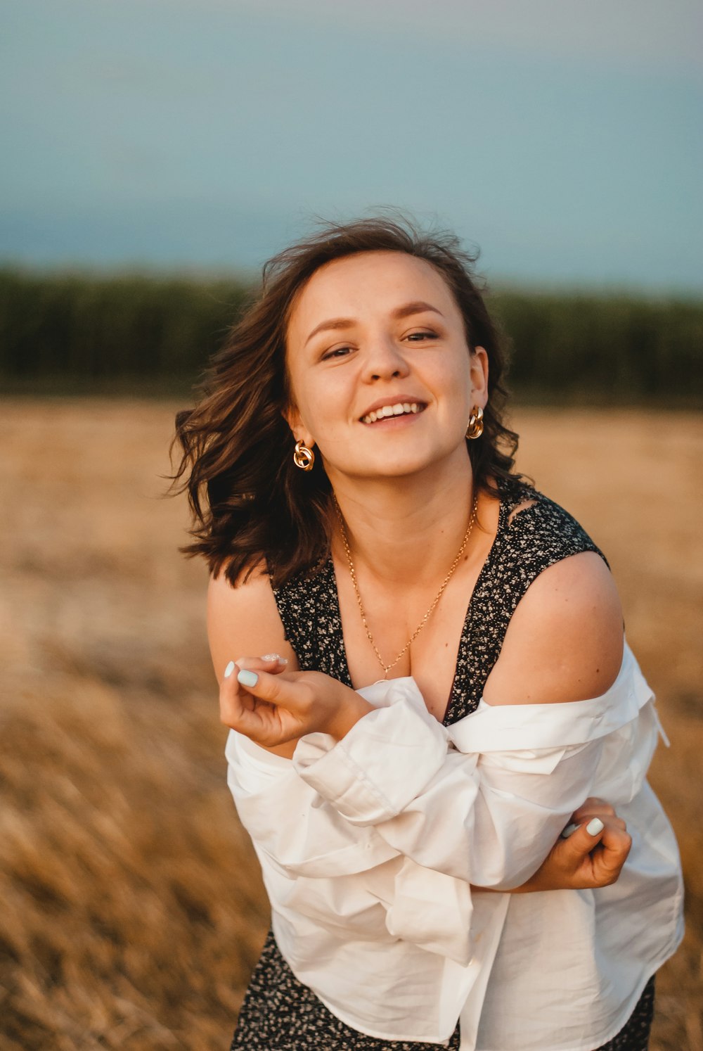 woman in black and white floral sleeveless top smiling