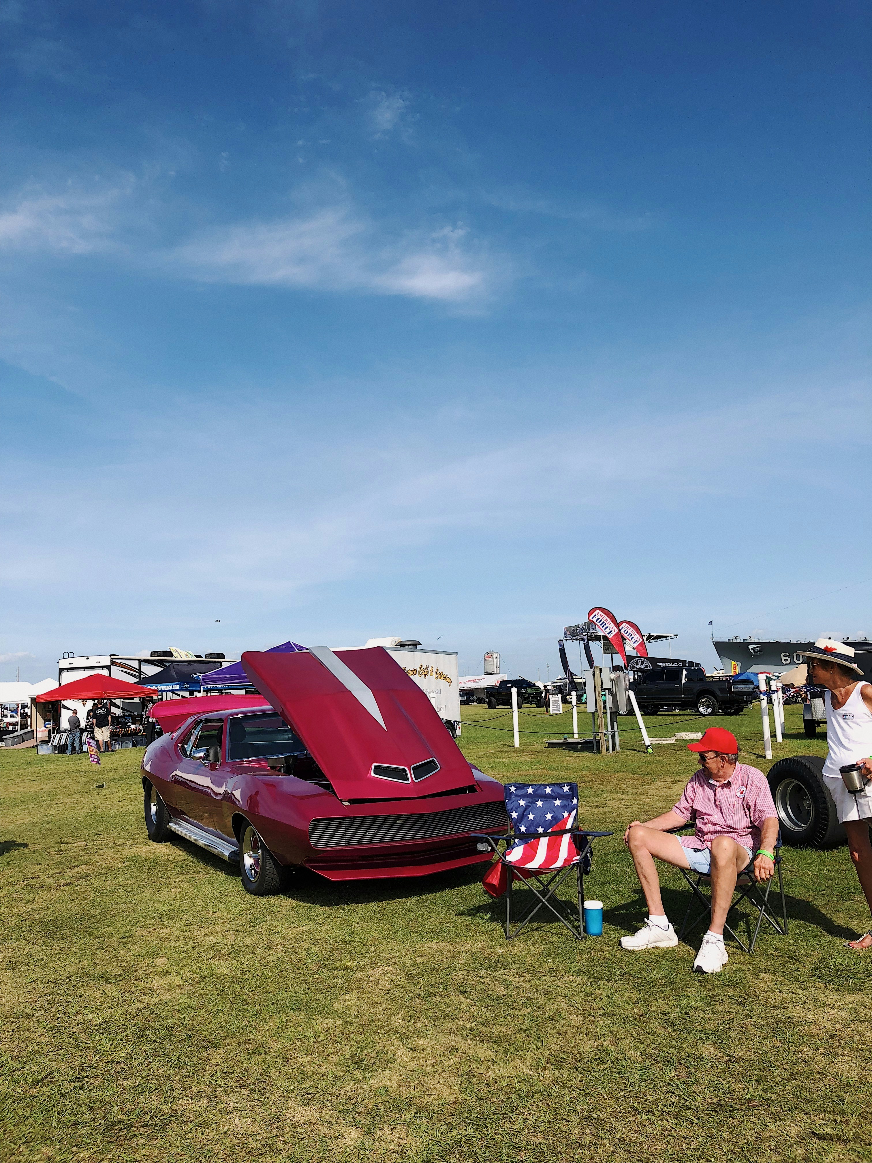 red and blue camping chairs on green grass field during daytime