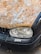 The image features the front section of a car with a heavily rusted hood and a black bumper. The right headlight is clearly visible, and there is a white sticker with the word 'porn' on the bumper.