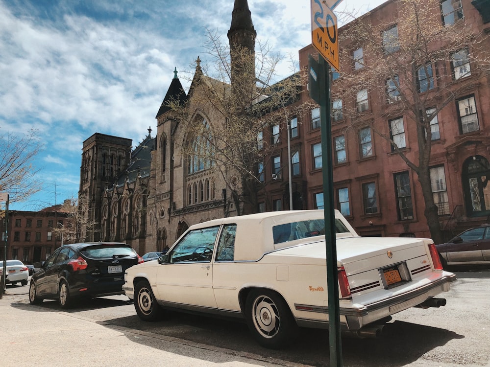 white sedan on road near brown concrete building during daytime