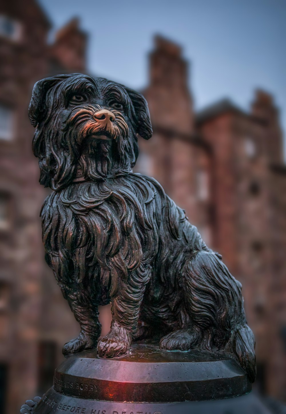 a statue of a dog sitting on top of a fire hydrant