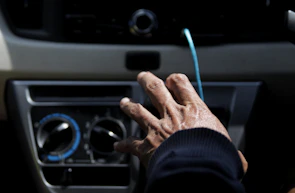 Close-up of a technician tuning acceleration and brake settings on a Club Car dashboard.