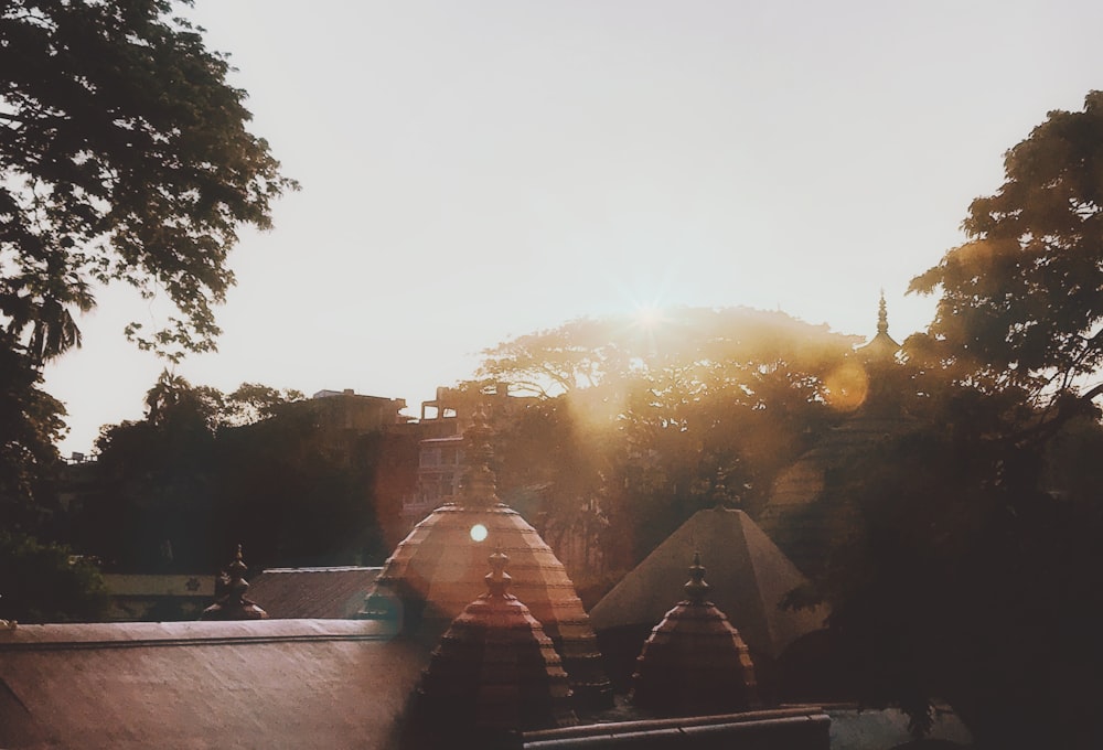 person in black jacket sitting on brown wooden bench during sunset