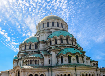 The green domes of Alexander Nevsky cathedral in Sofia against a blue sky
