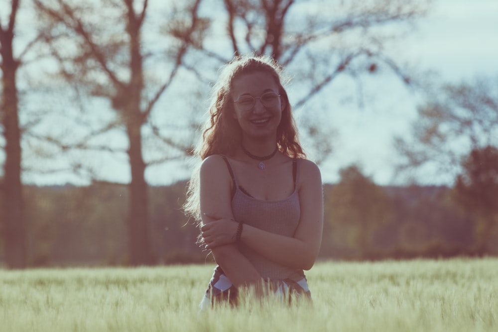 woman in brown long sleeve shirt sitting on green grass field during daytime