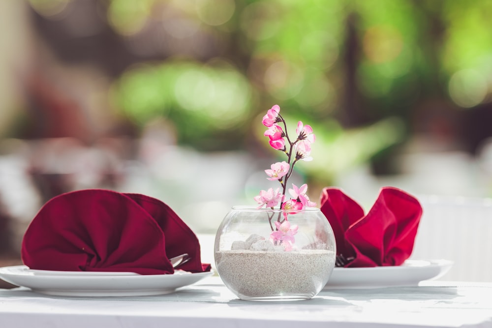 rosa Rosen in klarer Glasvase auf weißem Tisch