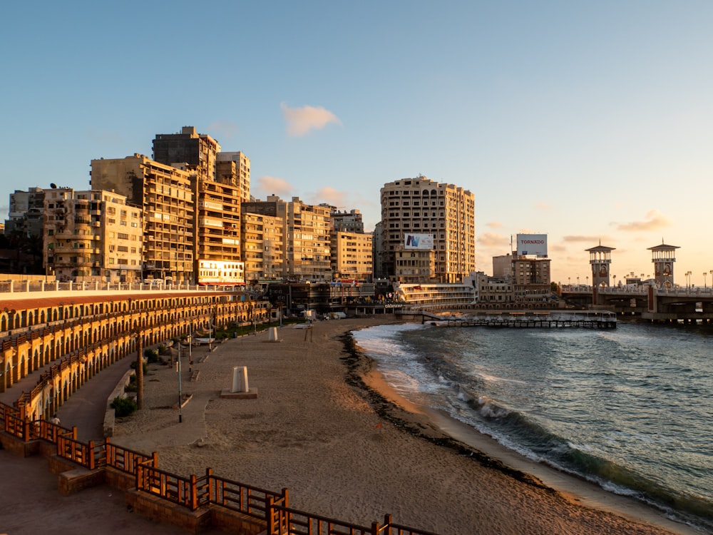 people walking on beach shore near high rise buildings during daytime