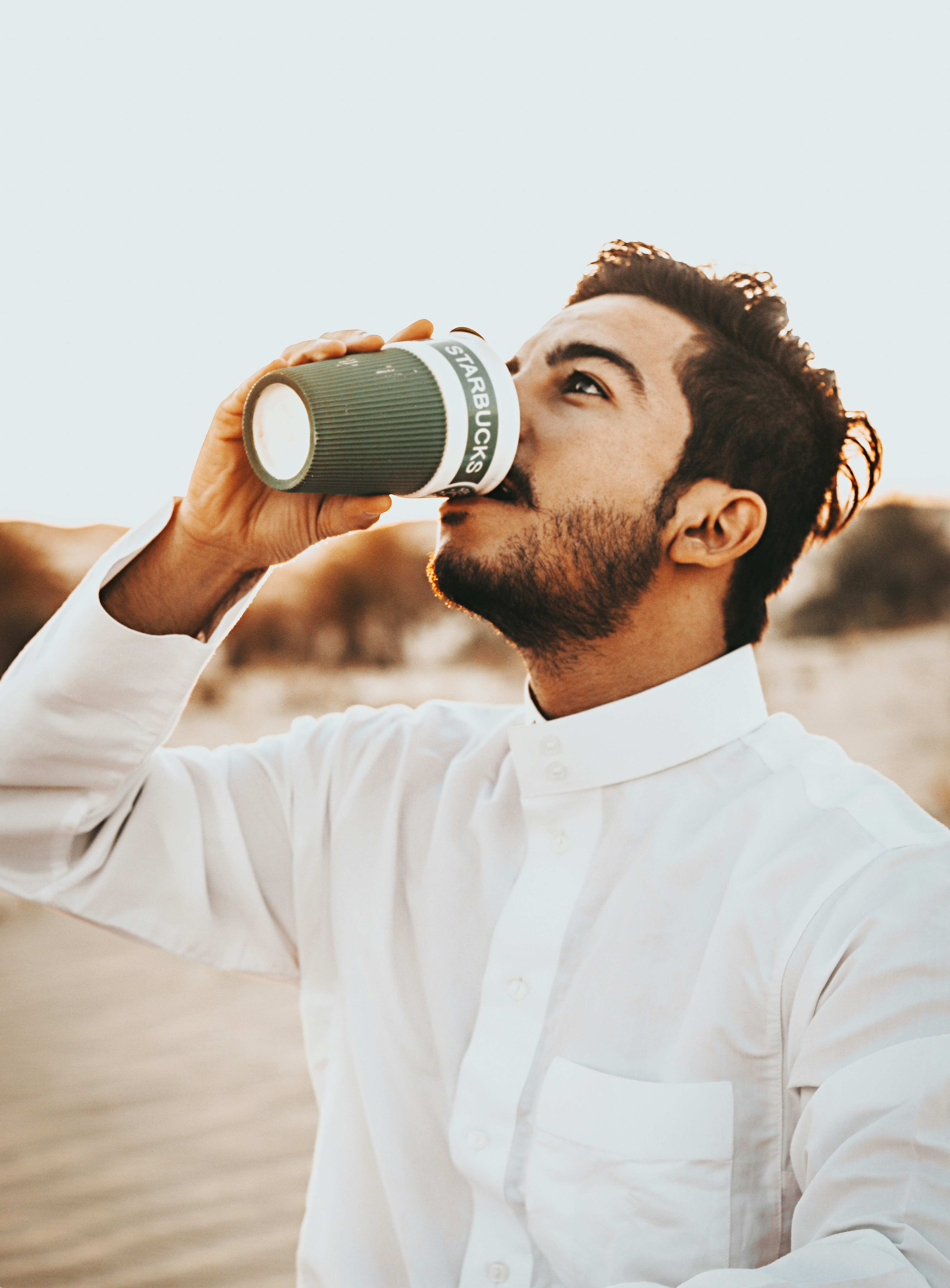 man in white dress shirt holding black camera lens